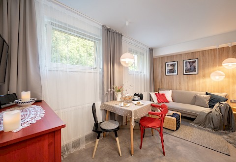 Červeně natřené tradiční židlové křeslo č. 24 od firmy TON tvoří svěží akcent v Apartmánu Kotelna